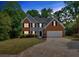 Beautiful two-story home with a brick and gray siding, and a well-manicured lawn at 5705 Cannonero Dr Dr, Alpharetta, GA 30005