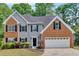Lovely two-story home with brick and vinyl siding, black shutters, and a neatly landscaped front yard at 5705 Cannonero Dr Dr, Alpharetta, GA 30005