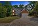 Charming two-story home with a brick and vinyl exterior, a well-manicured lawn, and an attached garage at 5705 Cannonero Dr Dr, Alpharetta, GA 30005