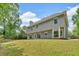 A rear exterior view of the house, with large yard, multiple windows and doors for enjoying the view at 5705 Cannonero Dr Dr, Alpharetta, GA 30005