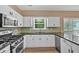 Bright kitchen featuring white cabinetry, granite countertops, and stainless steel appliances at 5705 Cannonero Dr Dr, Alpharetta, GA 30005