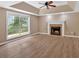 Spacious living room with laminate flooring, a tray ceiling, fireplace, and lots of natural light at 5705 Cannonero Dr Dr, Alpharetta, GA 30005