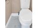 Close up of a white toilet with gray stone tile flooring and white baseboards at 5705 Cannonero Dr Dr, Alpharetta, GA 30005
