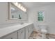 Bright bathroom features a large mirror, white vanity with drawers, and a toilet at 2689 Cosmos Ne Dr, Atlanta, GA 30345