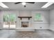 Cozy living room features a white brick fireplace, ceiling fan, skylight and access to the outdoor deck at 2689 Cosmos Ne Dr, Atlanta, GA 30345