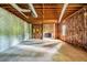 Unfinished basement featuring exposed beams, concrete floor, and brick fireplace at 441 Belgrave Ln, Tucker, GA 30084