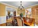 Open-concept dining room with elegant chandelier; view into kitchen and living room at 441 Belgrave Ln, Tucker, GA 30084