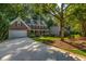 Brick home with dormers, shutters, covered porch, driveway, and beautiful landscaping at 441 Belgrave Ln, Tucker, GA 30084