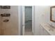 Bathroom with a vanity, mirror, and tiled shower; hallway is visible through the open doorway at 3101 Reeves Se St, Smyrna, GA 30080