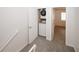 Hallway with carpet, white trim, and a closet housing a stacked washer and dryer at 3101 Reeves Se St, Smyrna, GA 30080
