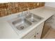 Stainless steel kitchen sink and dishwasher with tan tile backsplash at 3101 Reeves Se St, Smyrna, GA 30080