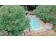 A fenced pool surrounded by chairs and tables with trees casting shade overhead at 3101 Reeves Se St, Smyrna, GA 30080
