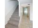 Carpeted staircase with white walls and handrail leads to a hallway with tile flooring and natural light at 3101 Reeves Se St, Smyrna, GA 30080