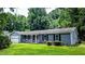Charming single-story home featuring a front porch, attached garage, and lush green lawn at 5177 Mccarter Sta, Stone Mountain, GA 30088