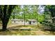Quaint single-story home with simple design surrounded by mature trees and greenery, creating a peaceful setting at 5177 Mccarter Sta, Stone Mountain, GA 30088