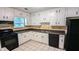 Functional kitchen with white cabinets, black appliances, and tile flooring at 5177 Mccarter Sta, Stone Mountain, GA 30088