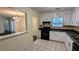 View of the kitchen featuring white cabinetry, tiled floors and a serving hatch into the dining area at 5177 Mccarter Sta, Stone Mountain, GA 30088