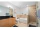 Bright bathroom with a vanity with black countertop, separate shower, and a soaking tub at 905 Juniper Ne St # 701, Atlanta, GA 30309