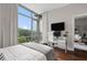Bright bedroom featuring a large window with a view, hardwood floors, and a comfortable sitting area at 905 Juniper Ne St # 701, Atlanta, GA 30309