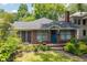 Charming brick home with landscaped front yard, screened porch, and blue front door at 1300 North Ne Ave, Atlanta, GA 30307