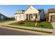 An inviting one-story home features a well-maintained lawn, a classic covered porch and a side entry two-car garage at 1693 Juniper Berry Way, Loganville, GA 30052