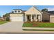 Charming single-story home boasts a manicured lawn, covered porch with columns, and an attached two-car garage at 1693 Juniper Berry Way, Loganville, GA 30052