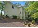 Back exterior of home featuring a patio with seating, garden beds and wooded views at 1755 Noblin Summit Dr, Duluth, GA 30097