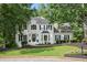 Charming two-story home with white exterior, black shutters, landscaped yard, and a welcoming front entrance at 1755 Noblin Summit Dr, Duluth, GA 30097