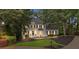 Charming two-story home with manicured lawn, mature trees, enhanced by tasteful exterior lighting and black shutters at 1755 Noblin Summit Dr, Duluth, GA 30097