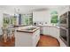 Open kitchen with white cabinetry, breakfast bar, and connection to sunroom at 1755 Noblin Summit Dr, Duluth, GA 30097