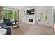 Spacious living room with built-in shelving, a fireplace, and large windows offering stunning views of the surrounding nature at 1755 Noblin Summit Dr, Duluth, GA 30097