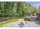Well-manicured backyard features a deck, a gravel area, a fire pit, and a privacy fence at 2070 Drew Valley Ne Rd, Brookhaven, GA 30319
