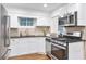 Modern kitchen with stainless steel appliances, white cabinets, and granite countertops at 2070 Drew Valley Ne Rd, Brookhaven, GA 30319