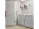 Functional laundry room equipped with a washer, dryer, and storage shelf for cleaning supplies at 4879 Seldon Se Way, Smyrna, GA 30080