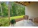 Covered patio with wicker chairs, table, and lush greenery beyond the iron fence at 1648 Danbury Parc Ne Pl, Brookhaven, GA 30319