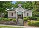 Elegant pool house with stone accents, surrounded by landscaped gardens and greenery at 1648 Danbury Parc Ne Pl, Brookhaven, GA 30319