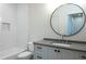Bathroom featuring subway tile, a round mirror, and a grey vanity with storage for a clean, modern look at 2164 James Aly, Atlanta, GA 30345