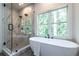 Spa-like bathroom with a soaking tub, a frameless glass shower, and a large window at 2164 James Aly, Atlanta, GA 30345