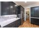Sleek kitchen features modern cabinets, stone countertops, and stainless steel appliances with open pantry at 2164 James Aly, Atlanta, GA 30345