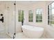 Bright bathroom features a standalone tub with views to the yard and a frameless shower at 805 Wesley Oak Rd, Atlanta, GA 30328