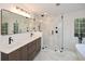 Bright bathroom features a double vanity with marble counters and a glass-enclosed shower at 805 Wesley Oak Rd, Atlanta, GA 30328