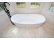 Bright bathroom features a standalone tub with a black faucet and white marble floors at 805 Wesley Oak Rd, Atlanta, GA 30328