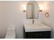 Modern powder room boasts elegant mirror, lighting, vanity with marble countertop, and a toilet at 805 Wesley Oak Rd, Atlanta, GA 30328