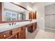 Well-lit bathroom boasts double sinks with wood cabinets, a large mirror, and tile flooring at 1235 Renaissance Se Ct, Mableton, GA 30126