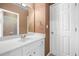 Neat bathroom with white vanity, a mirror, tiled shower, and a convenient linen closet at 1235 Renaissance Se Ct, Mableton, GA 30126
