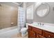 Bathroom featuring tub/shower, vanity with sink, and a round mirror at 1235 Renaissance Se Ct, Mableton, GA 30126