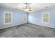 Bedroom with carpet, two windows, a ceiling fan, and a tray ceiling at 1235 Renaissance Se Ct, Mableton, GA 30126