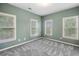 Bright bedroom with soft green walls, three windows, and neutral carpeting at 1235 Renaissance Se Ct, Mableton, GA 30126
