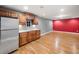 Basement kitchenette featuring wood cabinets, a stainless steel refrigerator, and wood floors at 1235 Renaissance Se Ct, Mableton, GA 30126