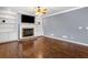 Cozy living room featuring hardwood floors, stone fireplace, a ceiling fan, and built-in bookshelves at 1235 Renaissance Se Ct, Mableton, GA 30126